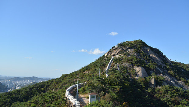 Fortress Wall of Seoul yang kontras dengan hijau pepohonan mengantar pendaki sampai ke puncak Inwangsan